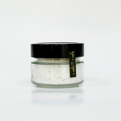 Sea salt in a 100g glass jar, showing the quantity and texture. Perfect for enhancing the taste of food.