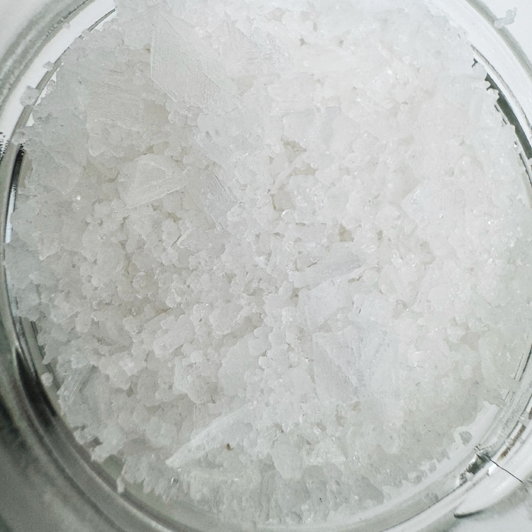 Close-up of sea salt inside a [quantity]g glass jar. Flaky texture and pure, salty flavor